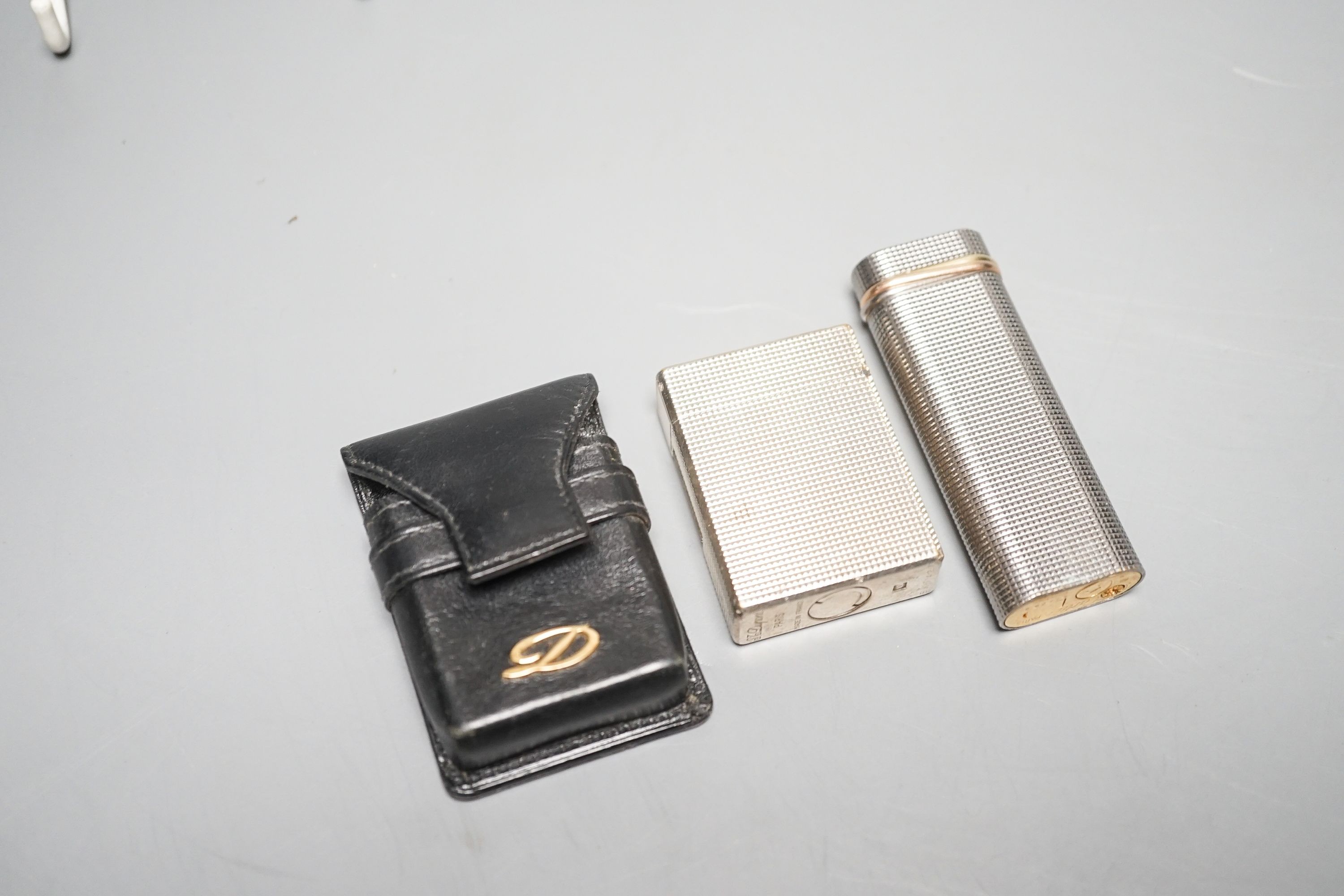 A Cartier engine turned lighter and a similar cased Dupont lighter